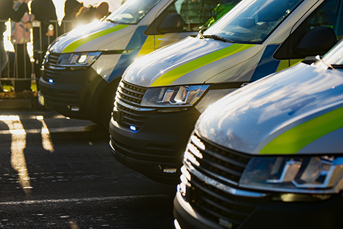 Front view of three emergency response vehicles parked side by side with sunlight reflections.