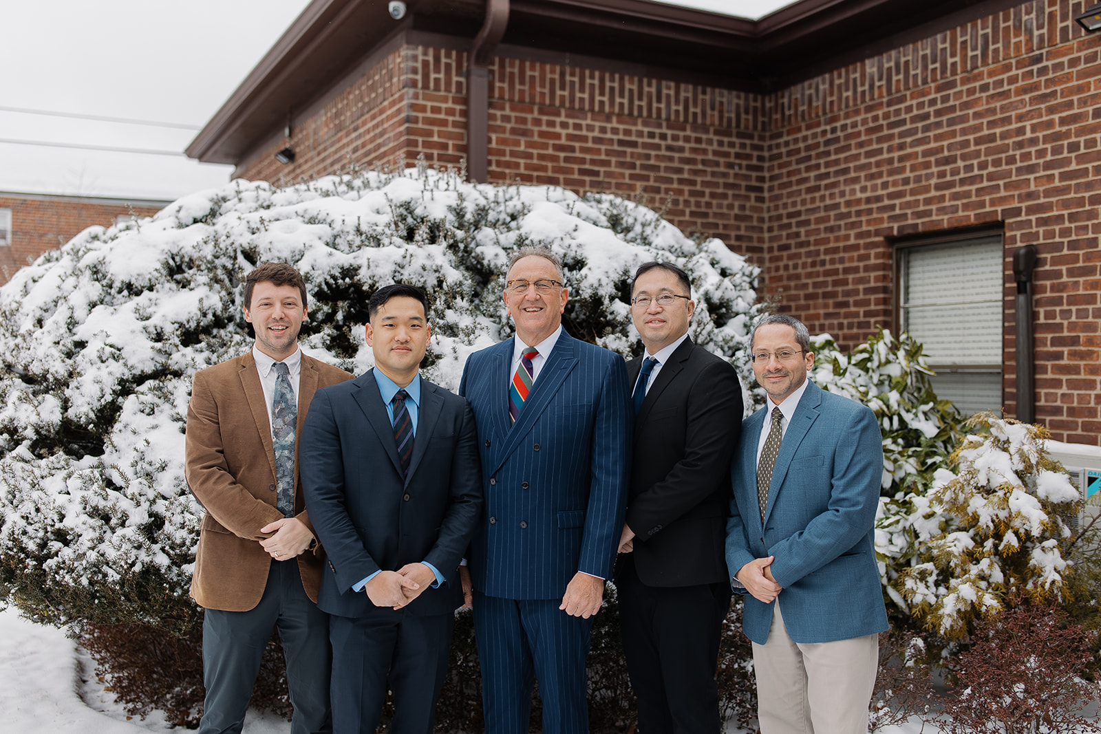 Pastors and Elders of North Shore Baptist Church of Bayside, NY standing in front of the church building on a snowy day.