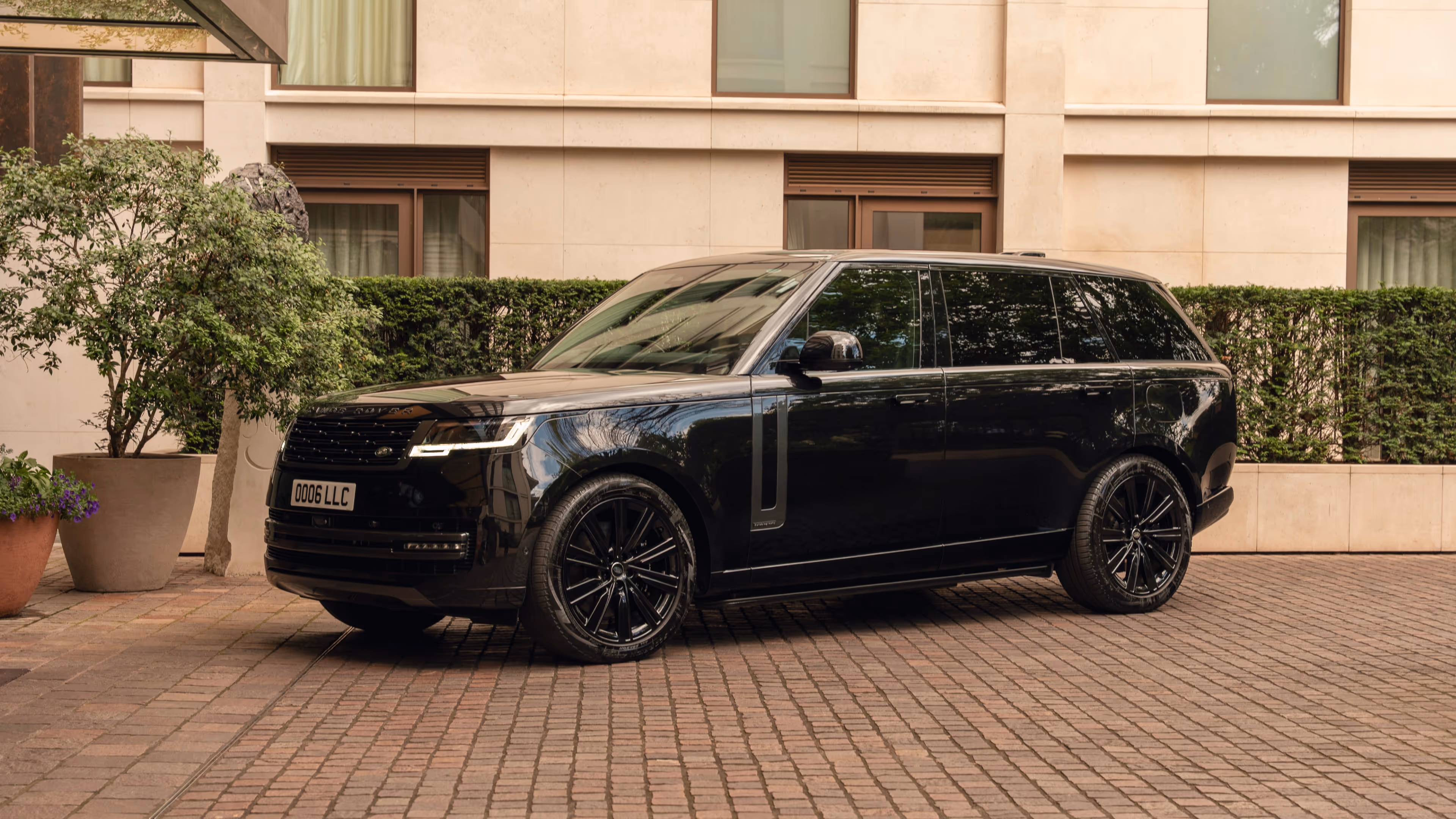 Side profile of a sleek black Range Rover Autobiography parked on a London street, part of LLC’s luxury chauffeur fleet