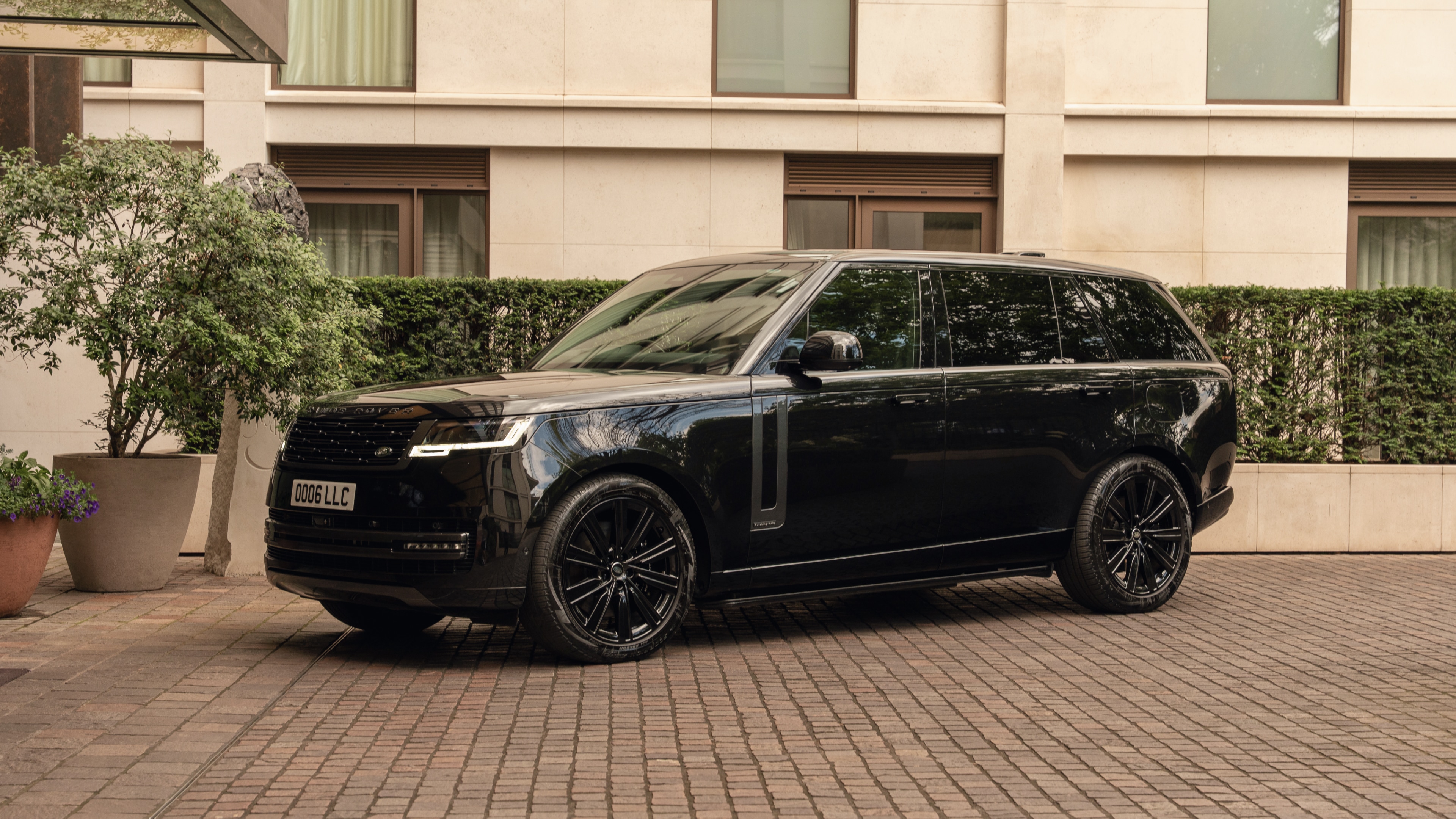 Side profile of a sleek black Range Rover Autobiography parked on a London street, part of LLC’s luxury chauffeur fleet