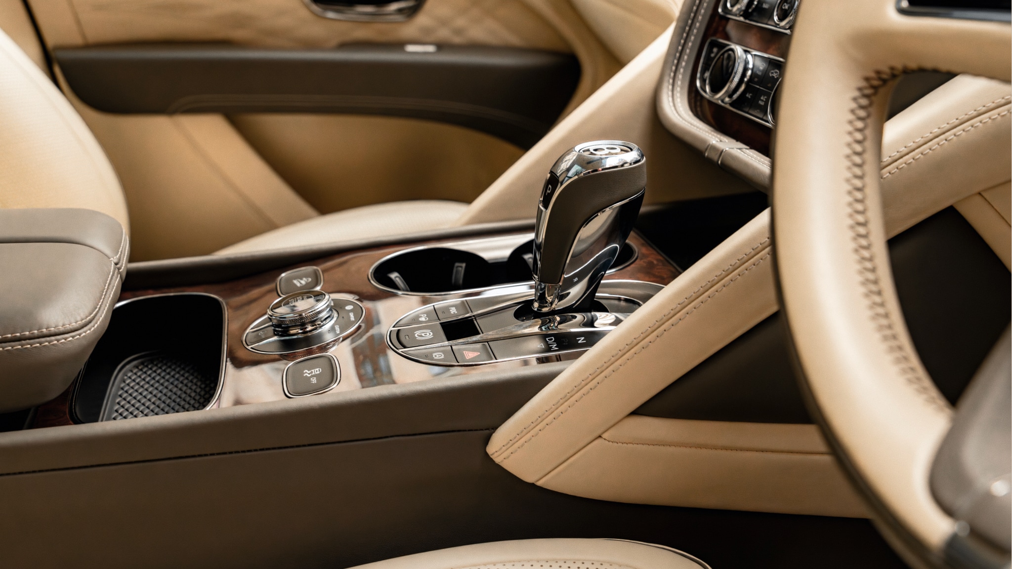 Bentley Bentayga interior featuring hand-stitched leather seats, wood veneer, and advanced infotainment system