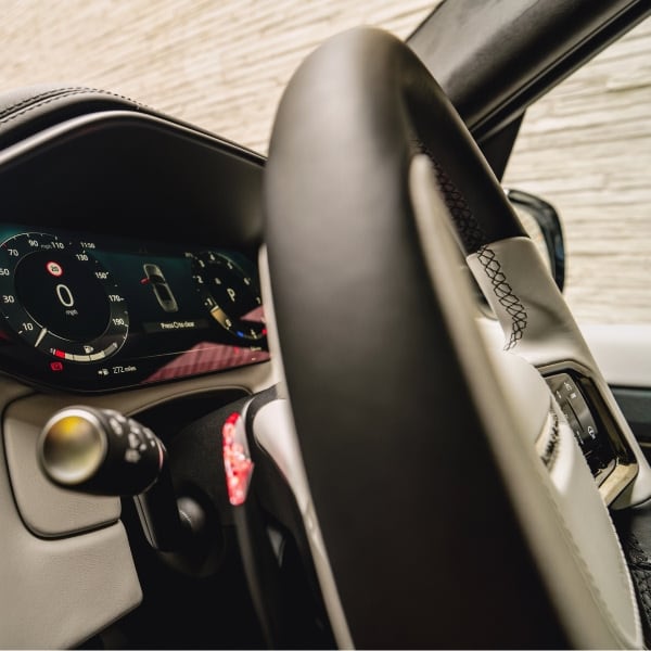 A driver-focused view of the performance steering wheel and the clear, high-resolution digital gauge cluster, underscoring the dynamic nature of the SV's interior design.