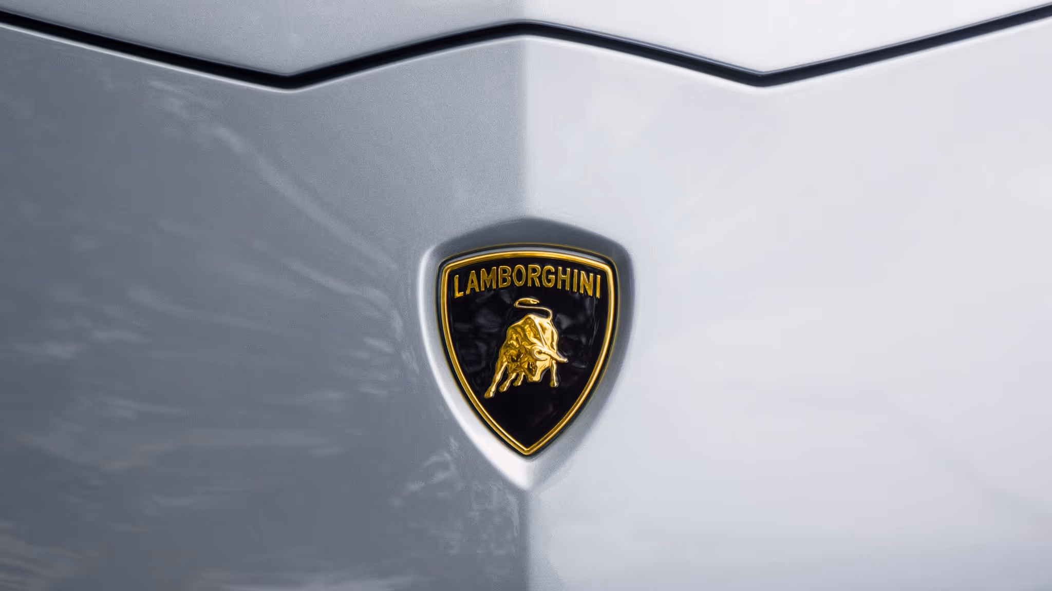 Close-up of the gold and black Lamborghini shield, highlighting the brand's presence in LLC’s high-performance supercar fleet.