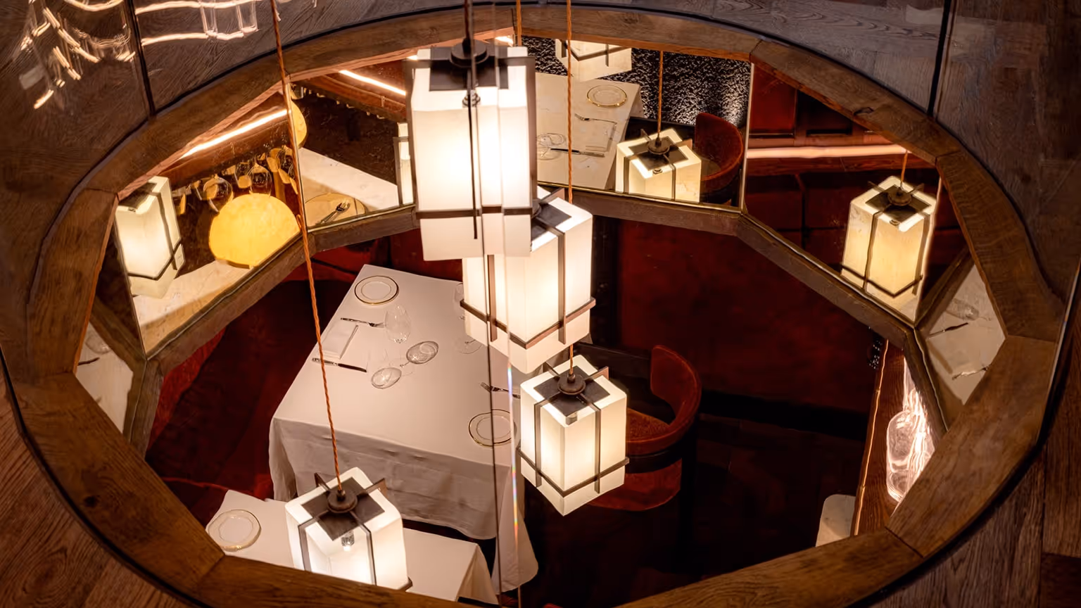 A refined overhead view of Aragawa Mayfair’s intimate dining space, featuring soft geometric lanterns, white-linen tables, fine china— captured to reflect the restaurant’s exclusive luxury atmosphere, ideal for LLC’s bespoke concierge dining experiences.
