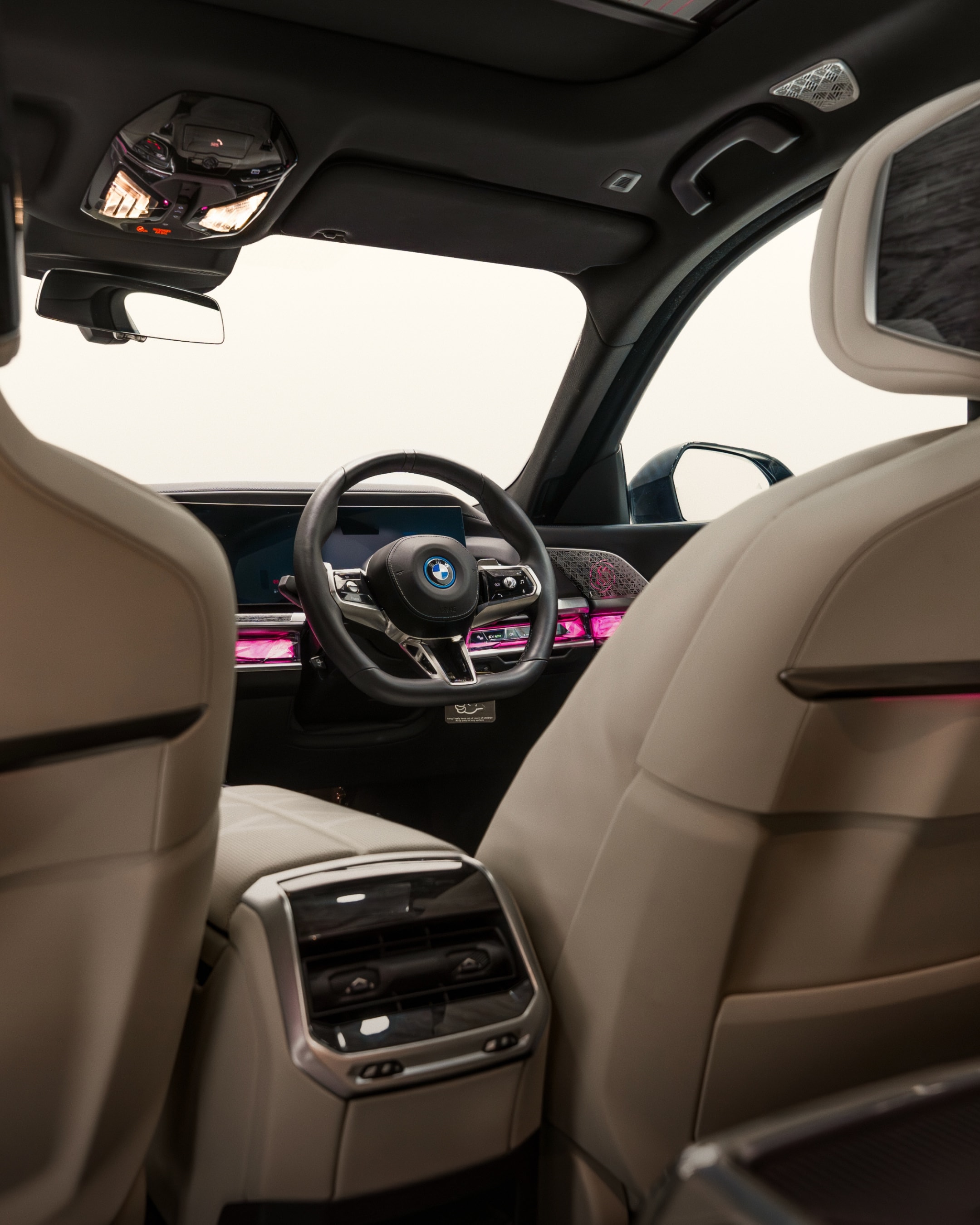 Side profile of a long-wheelbase BMW 7 Series chauffeur car with rear privacy glass.