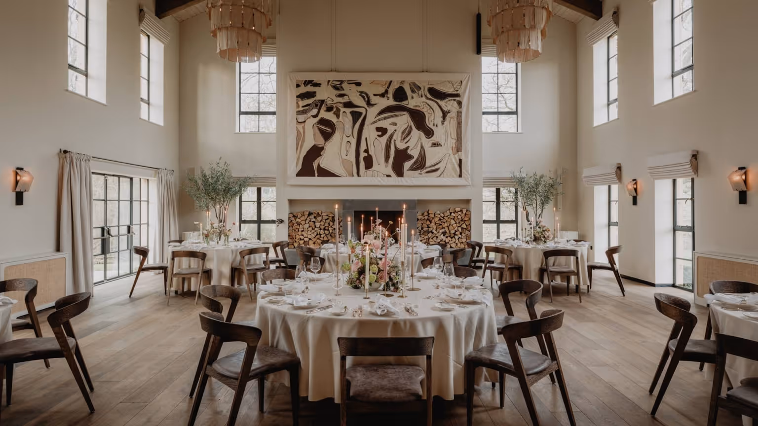 Elegant farmhouse-style dining space with vaulted ceilings and dressed round tables, designed for private celebrations, executive retreats, and bespoke gatherings.