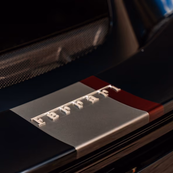 Close-up of the Ferrari 296GTB rear spoiler with the Ferrari badge and Italian tricolour detail.