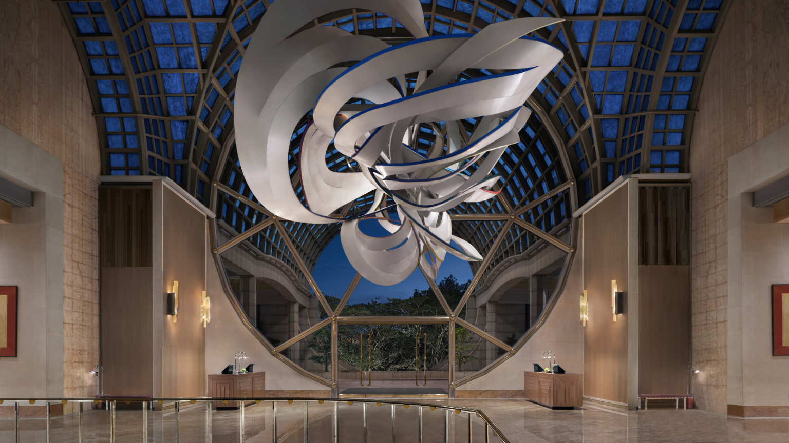 Lobby of The Ritz-Carlton, Millenia Singapore featuring a large suspended sculpture beneath a glass atrium ceiling.