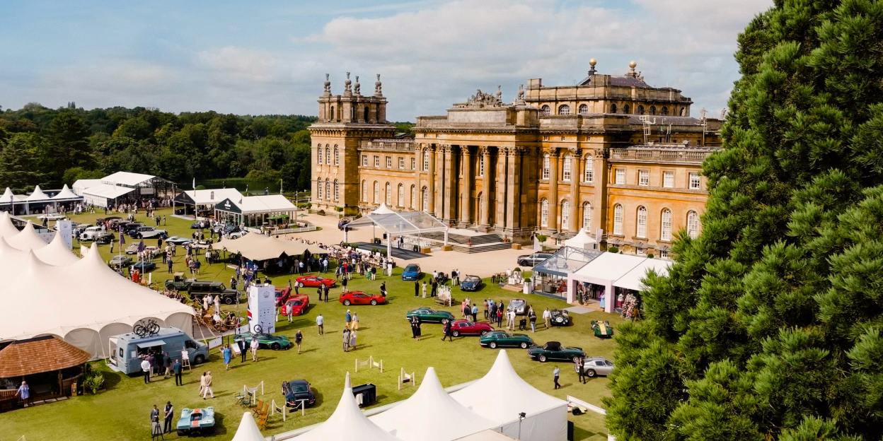 Aerial view of Salon Privé at Blenheim Palace, with classic and luxury cars displayed across the South Lawn, hospitality marquees, guests and the palace in the background.
