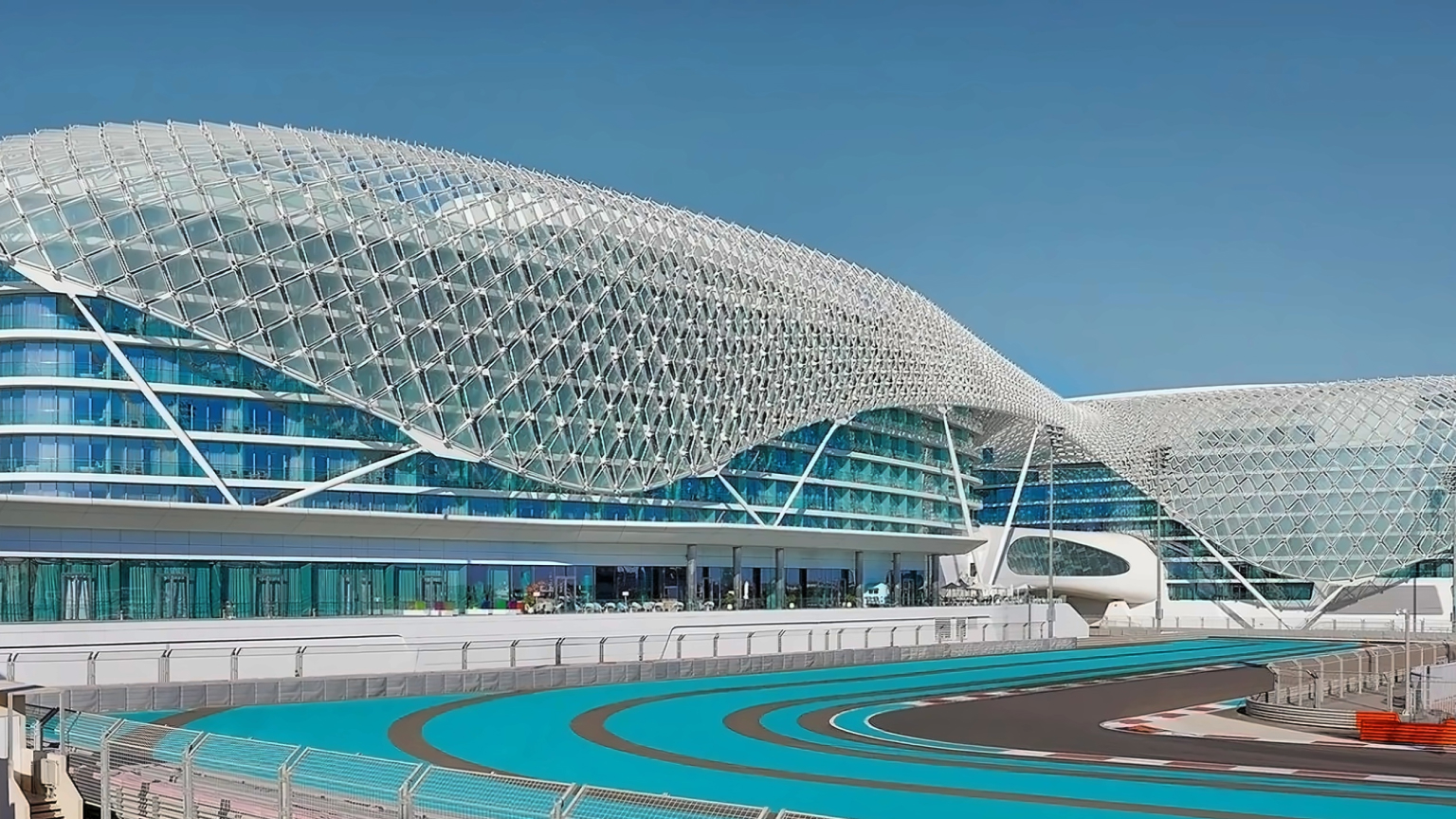 Exterior of W Abu Dhabi – Yas Island beside the Yas Marina Circuit, showing its distinctive geometric canopy and the race track in the foreground.
