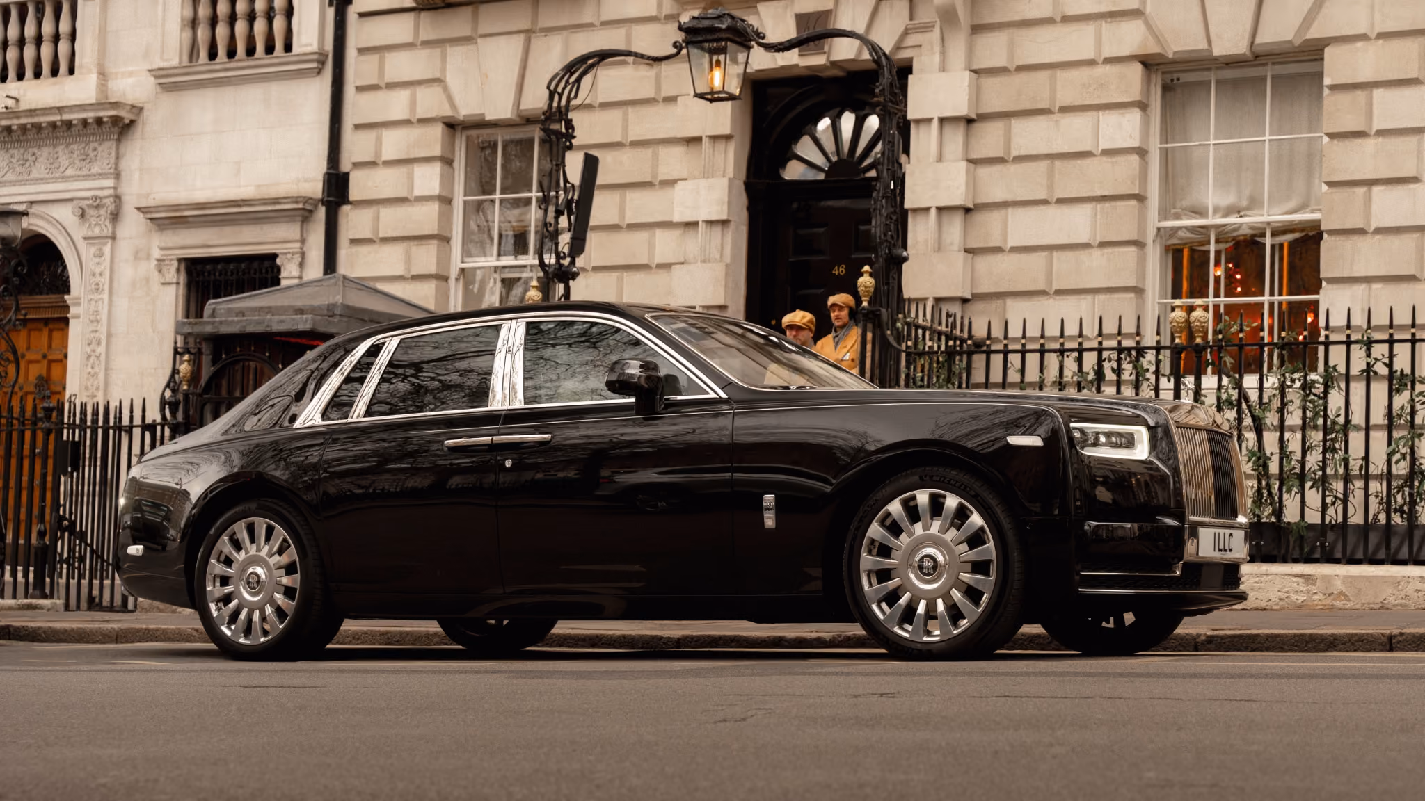 Black Rolls-Royce Phantom parked outside a traditional London townhouse during a chauffeur service.