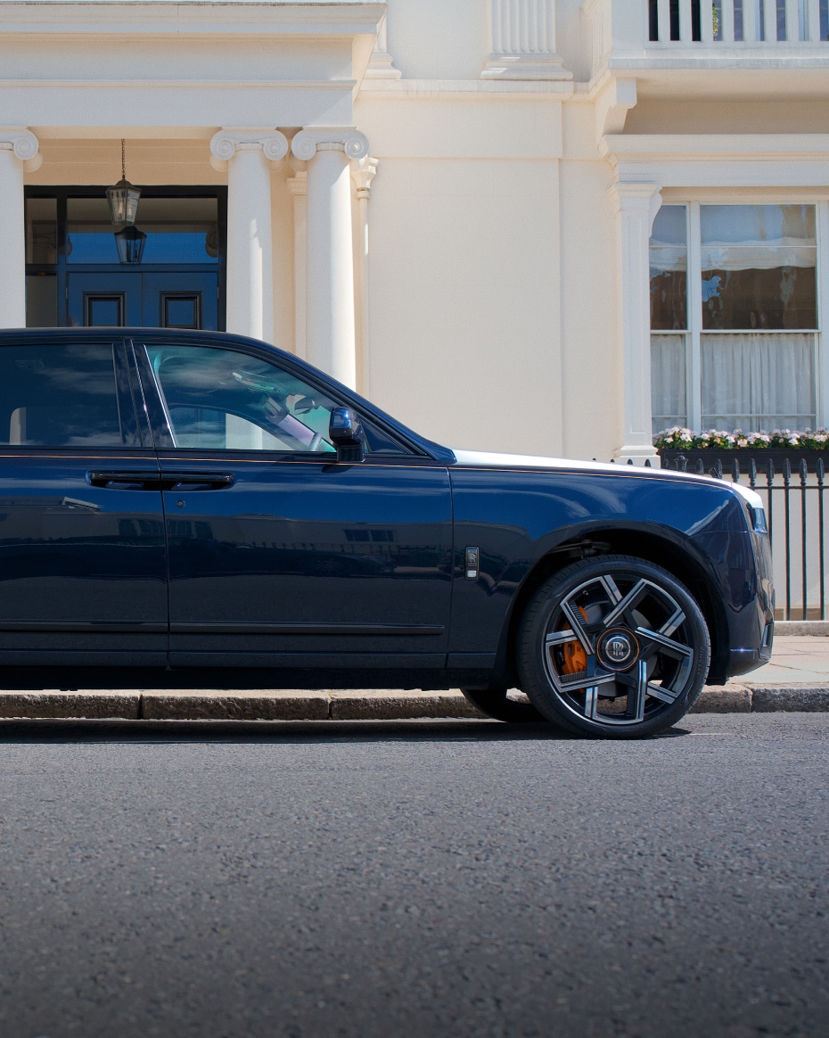 Side view of a Rolls-Royce Cullinan parked on a London street, highlighting its full-size luxury SUV proportions and distinctive profile.