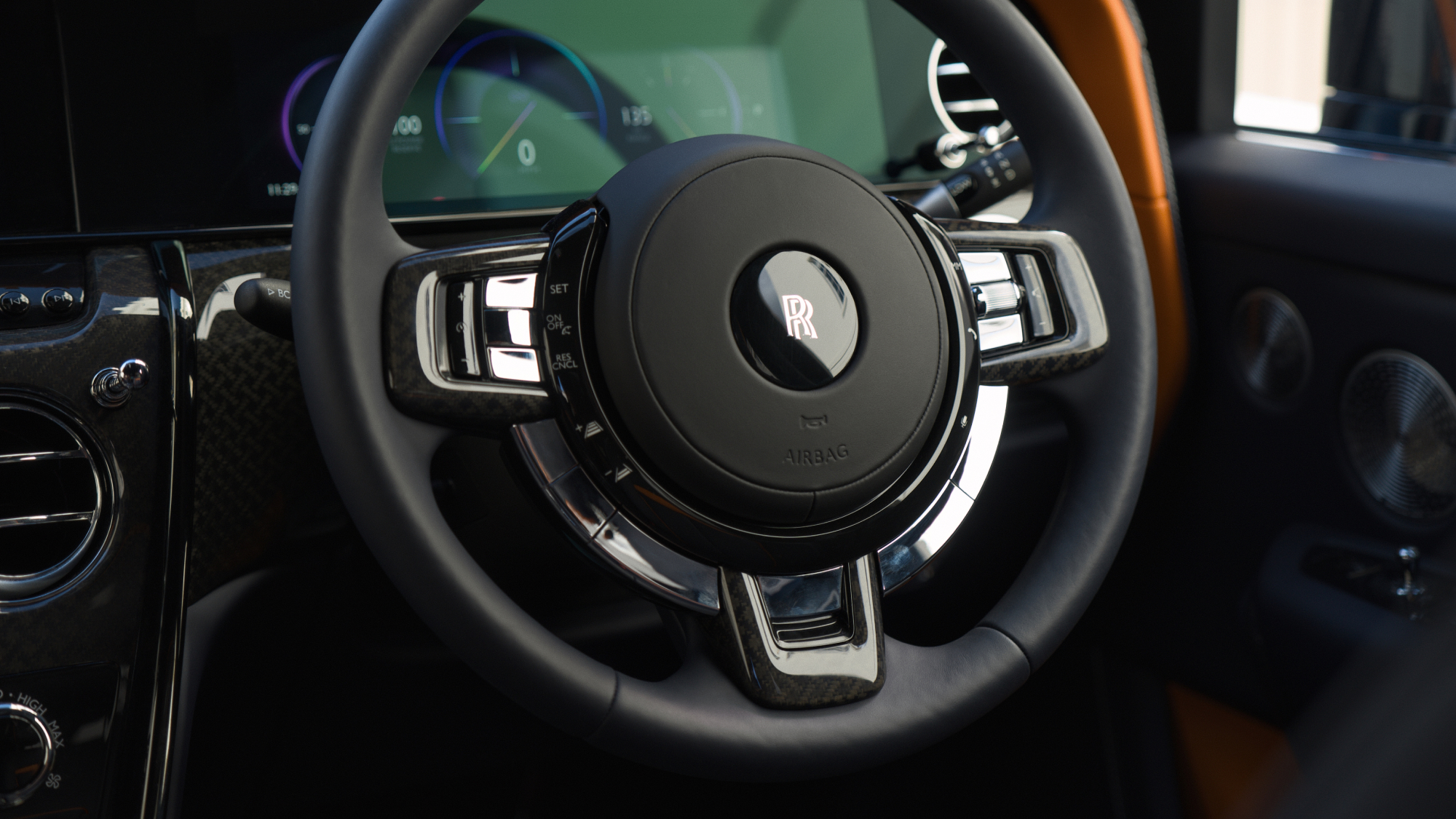 Close-up of the Rolls-Royce Cullinan steering wheel and digital cockpit, highlighting refined materials, polished detailing and the vehicle’s premium interior craftsmanship.