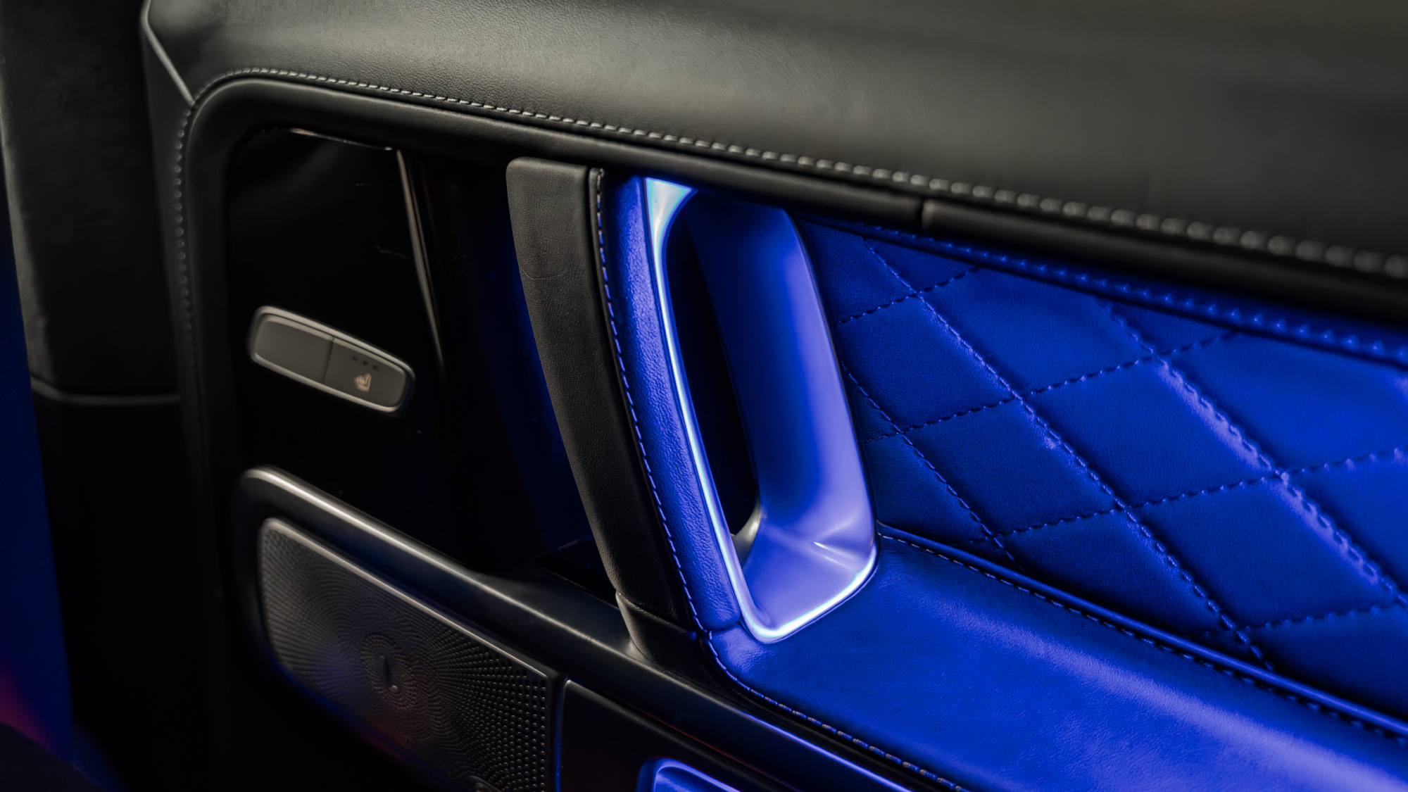Mercedes-Benz G-Class interior door panel with quilted leather trim and premium metal detailing.