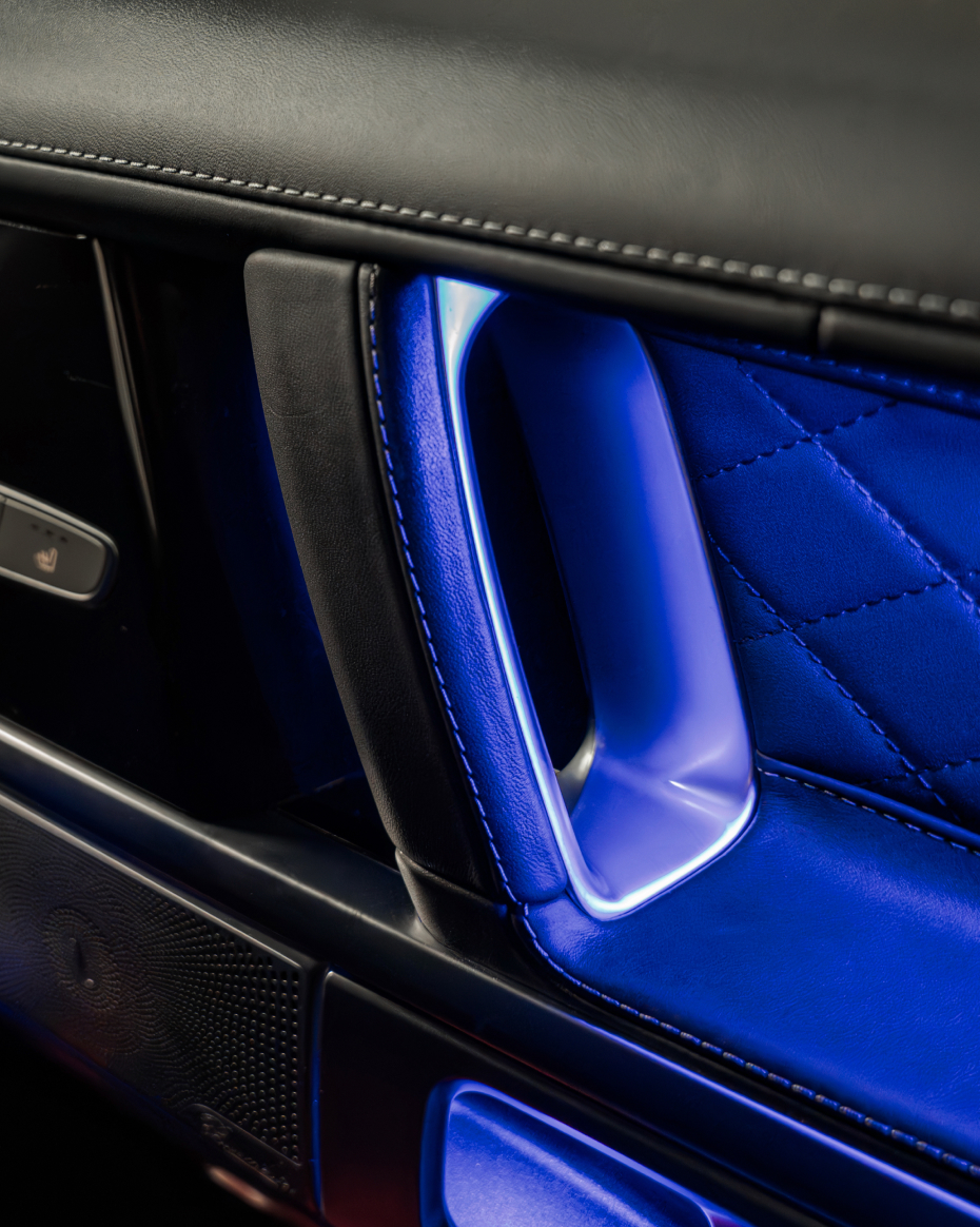 Mercedes-Benz G-Class interior door panel with quilted leather trim and premium metal detailing.