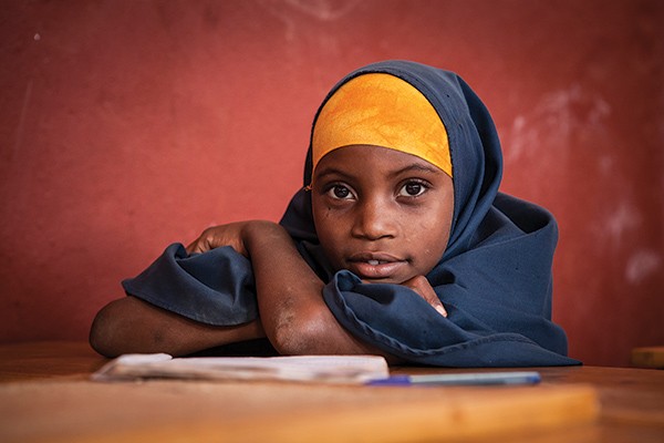 portrait of a young school girl seated at a desk
