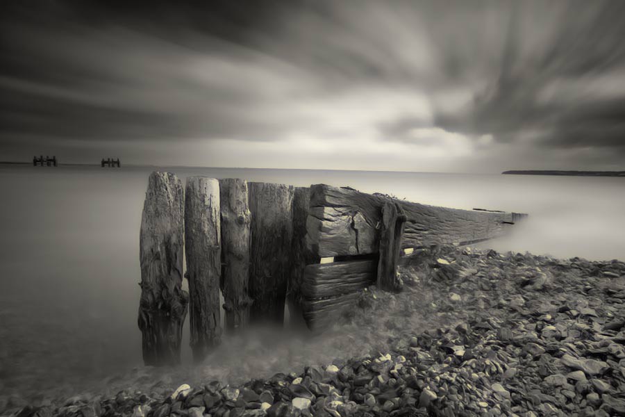 pebbles and pier on shore