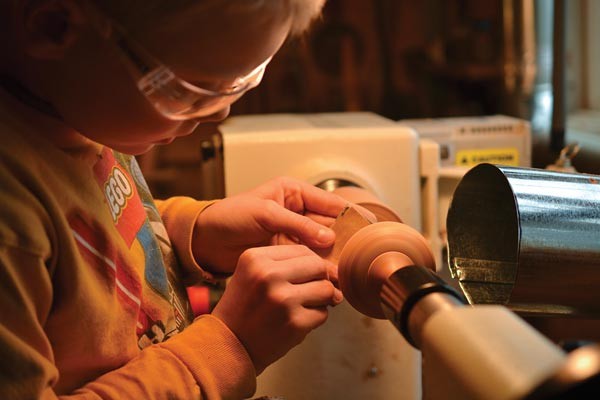 My oldest son Obediah is turning a small wooden top on the lathe.