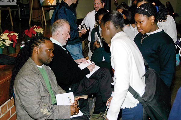Hashim Garrett, left, joins Christoph signing books after a Breaking the Cycle assembly.