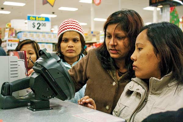 Bhutanese refugees using a food stamp card at a grocery store in Austin, Texas
