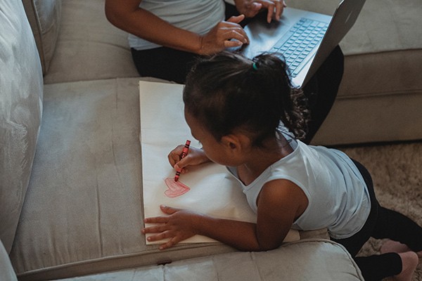 a little girl coloring a heart on a piece of paper