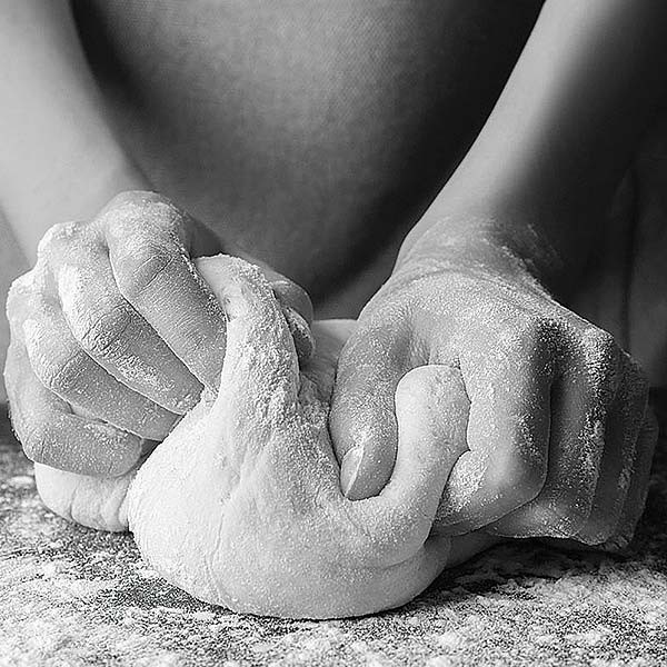 person kneading dough