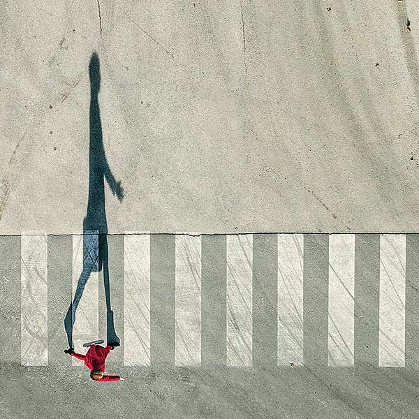 overhead view of a young woman in red on a crosswalk