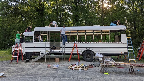 people working on renovating a bus