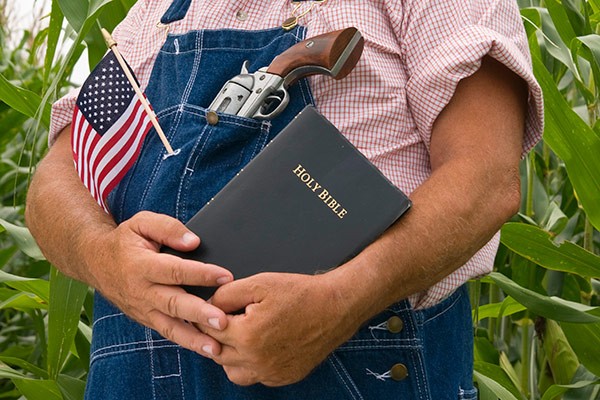 a farmer with a Bible, gun and American flag