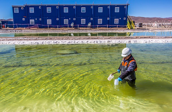 a man monitors the lithium extraction process in an evaporation pool