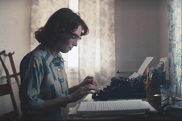 a woman typing on a typewriter