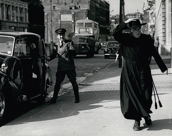 a priest walking down a street