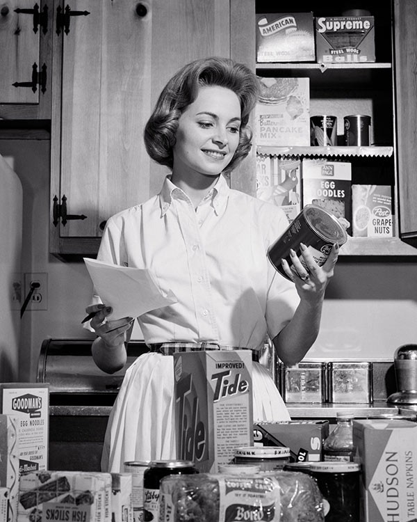a woman with groceries in a kitchen