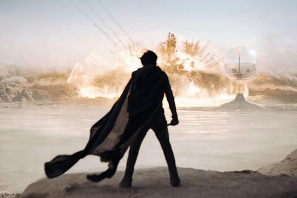 silhouette of a man standing in a desert landscape