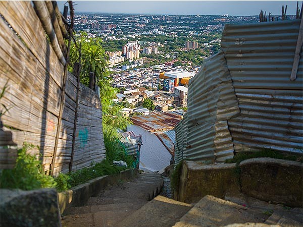 Vista de Cali desde el punto alto de unas escaleras, lindadas de barreras de chapa.