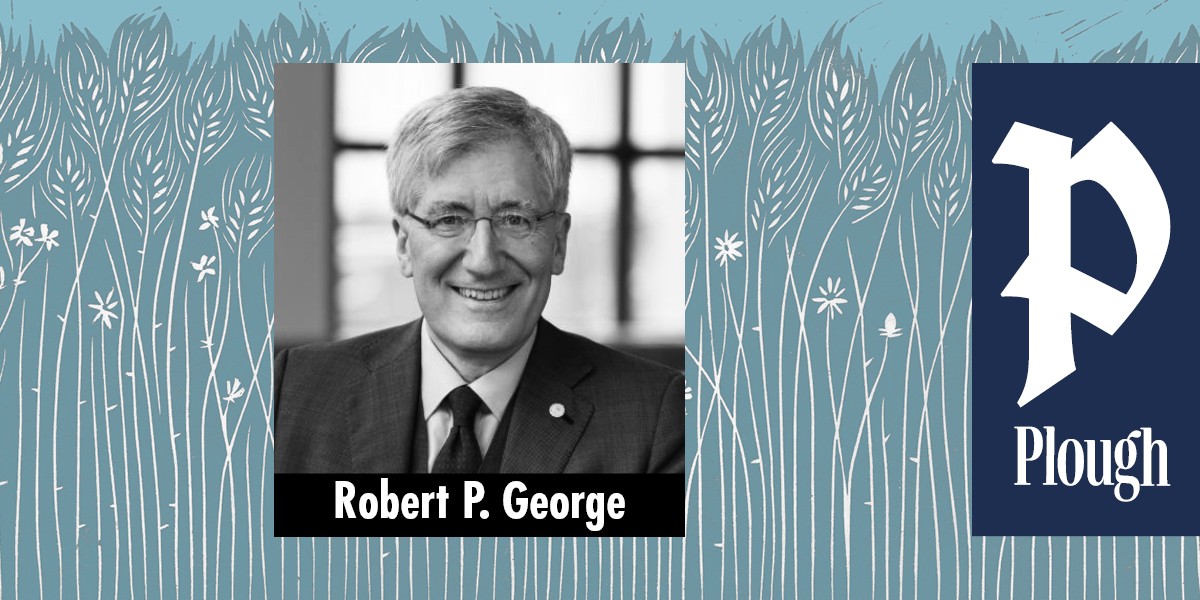 Black and white portrait of Robert P. George in a suit and tie smiling in front of a window.