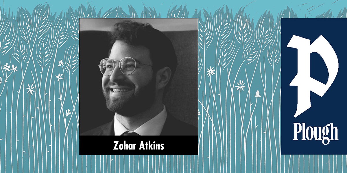 Portrait of smiling man with glasses and beard in suit and tie labeled Zohar Atkins.