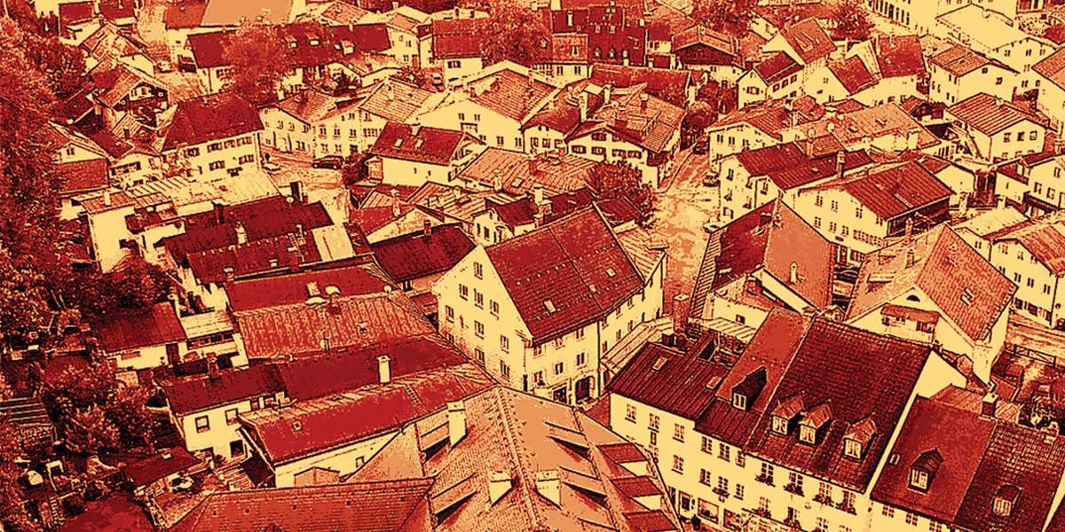 Aerial view of densely packed roofs and buildings in a town with a red color filter effect.