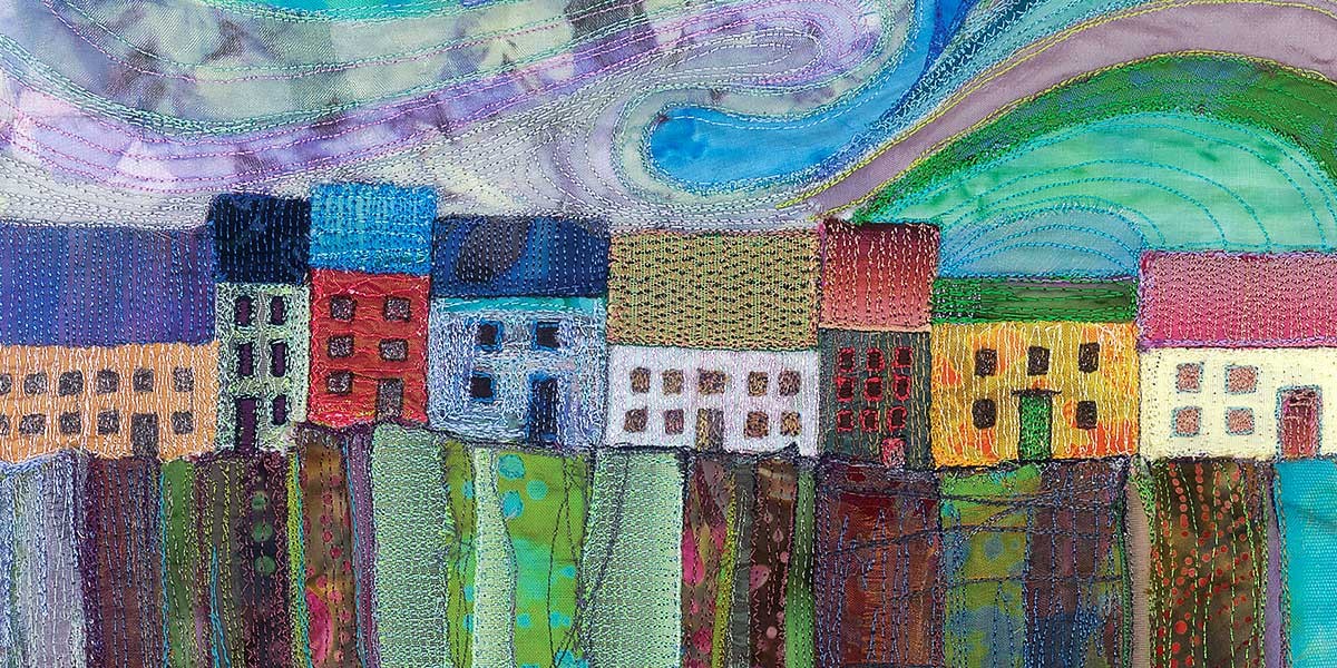 Colorful fabric art depicting a row of patchwork houses with abstract hills and sky above.