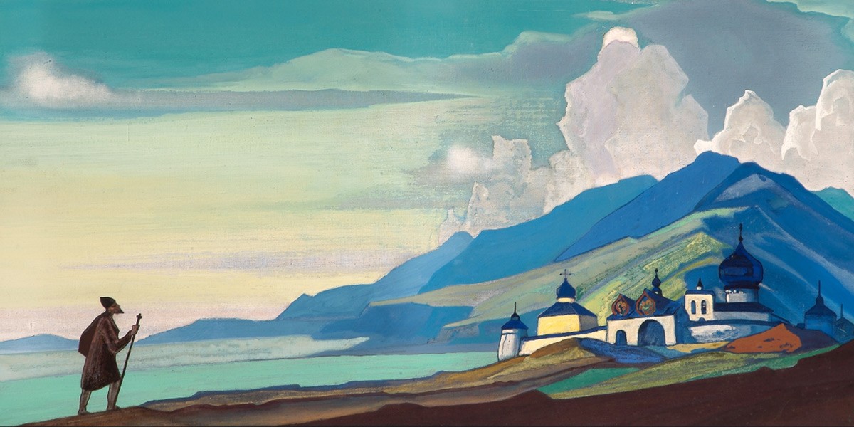Person with a walking stick looking at a distant blue-domed church by mountains under a cloudy sky.