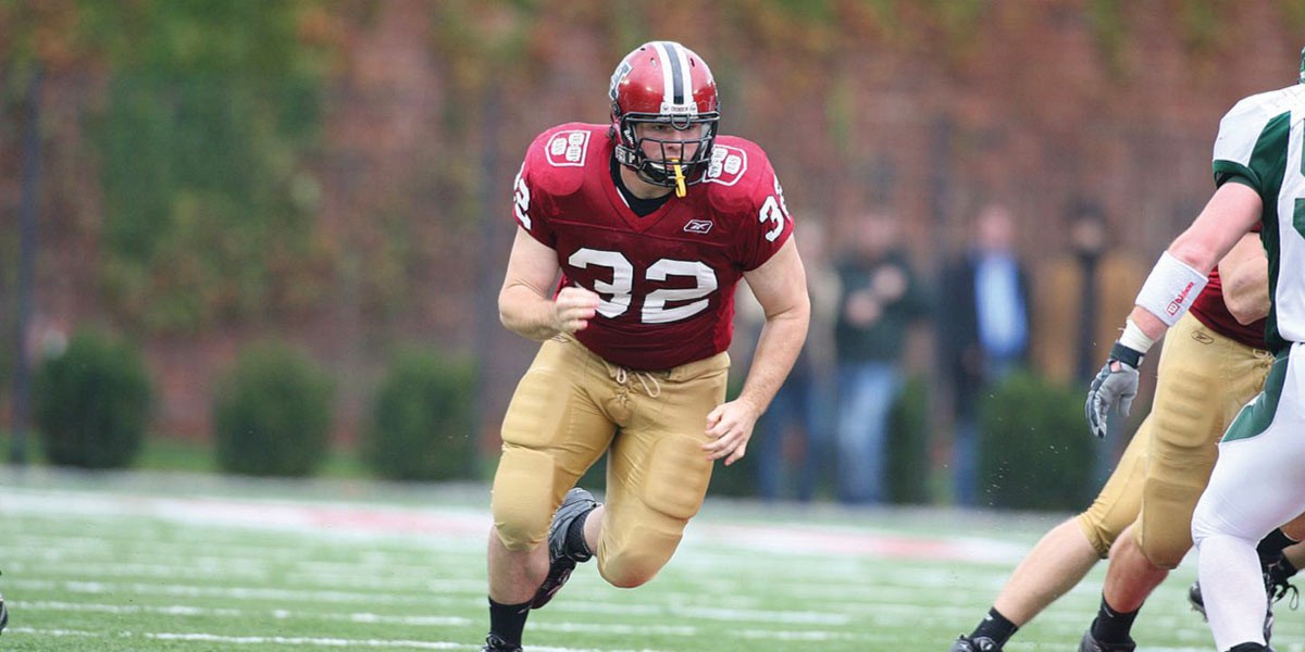 Football player in red jersey number 32 running on field during a game.