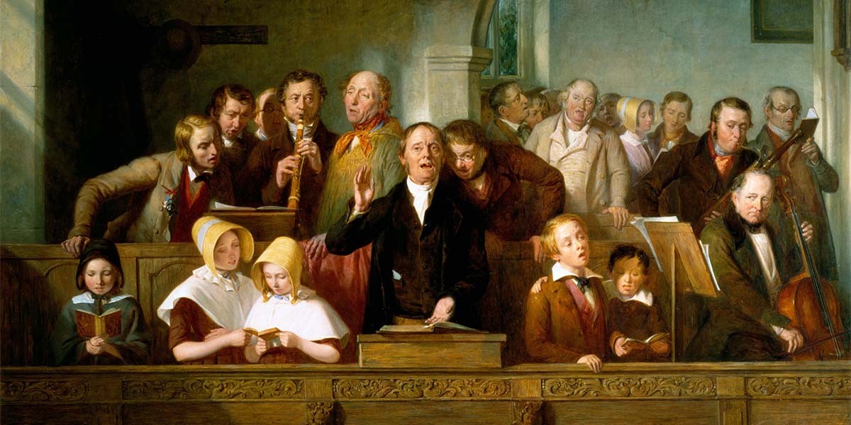 A group of men, women, and children singing and playing instruments in a church setting.