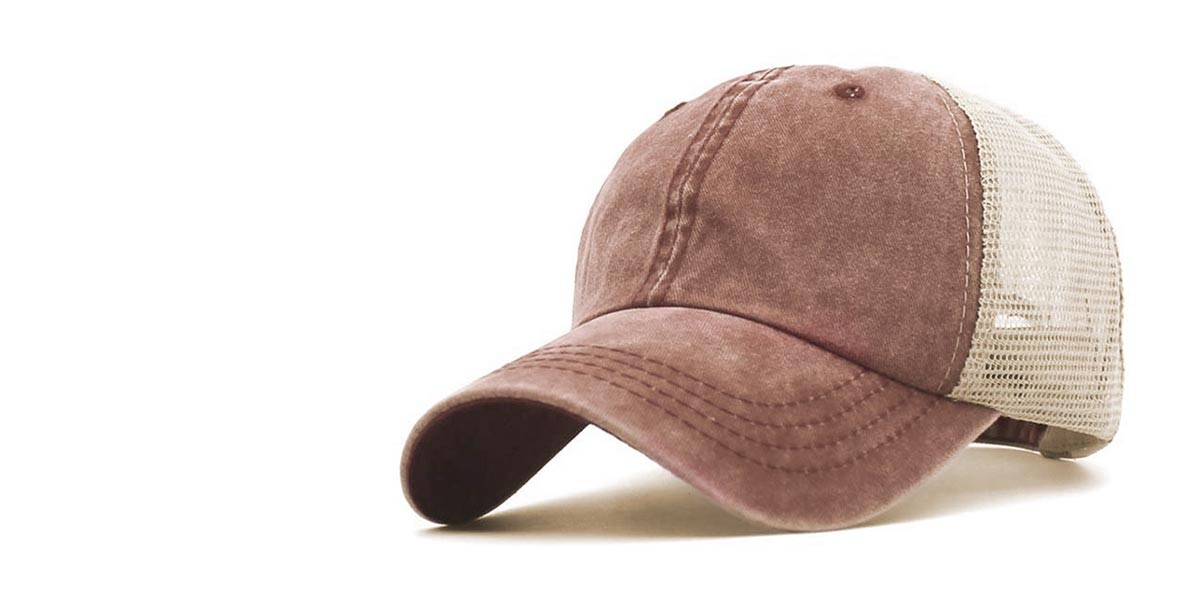 Brown baseball cap with a beige mesh back lying on a white surface.