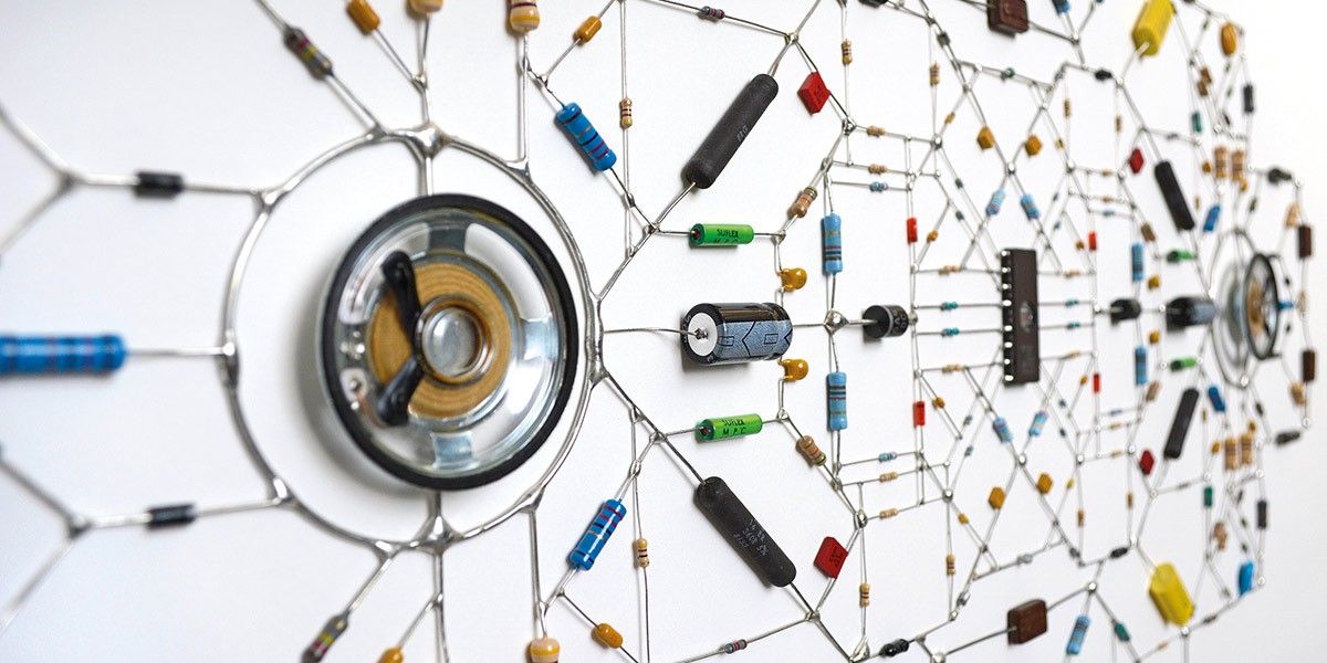 Close-up of an artistic wall installation made of electronic components arranged in hexagonal patterns.