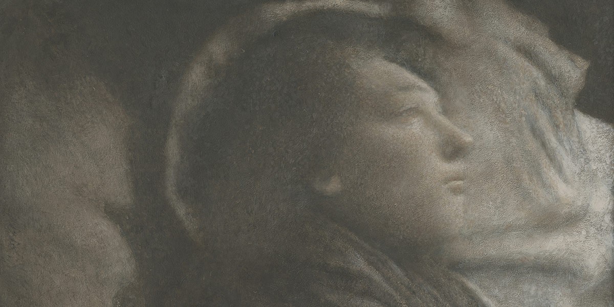 Softly lit grayscale close-up of a person's face in profile with a contemplative expression.