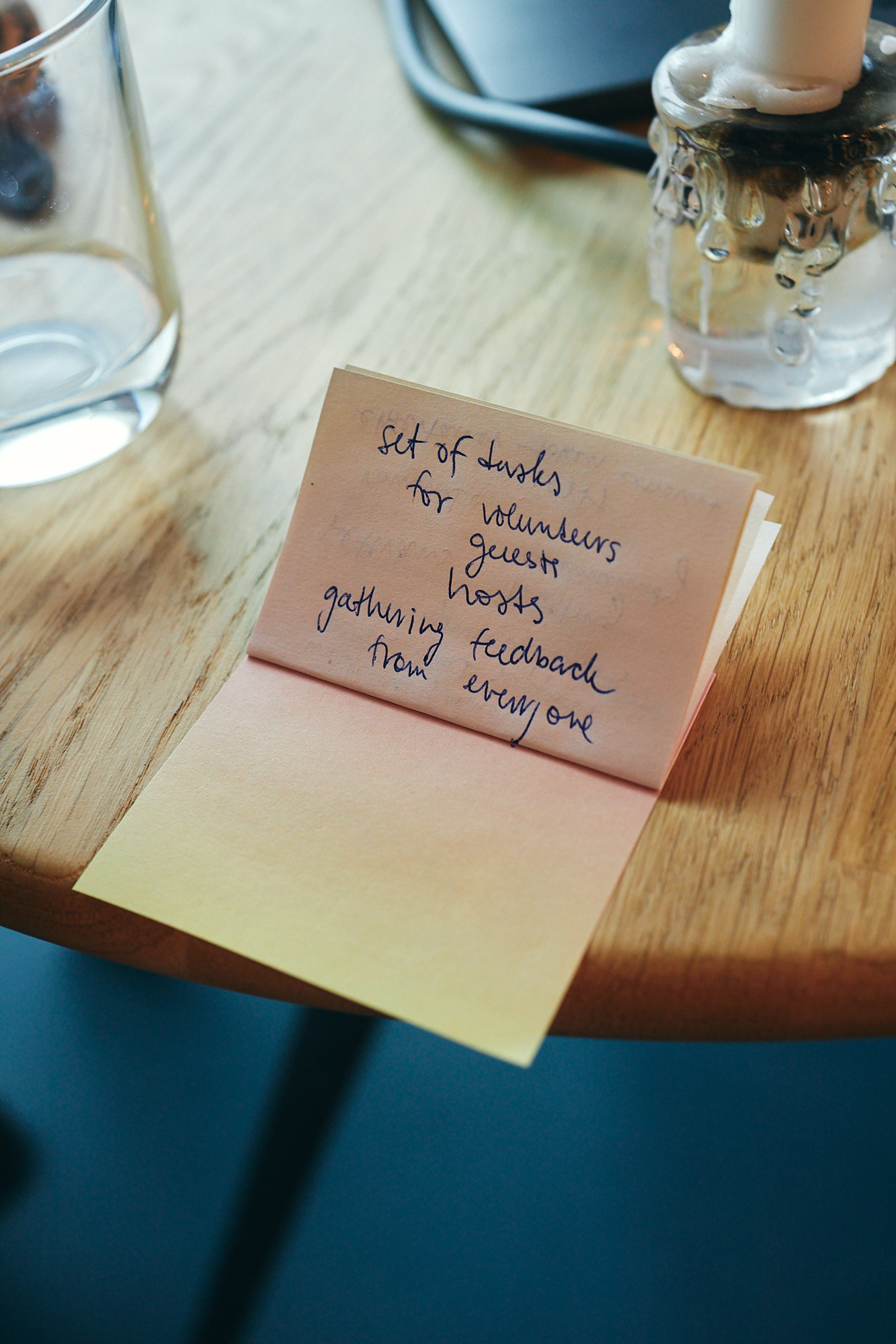 A note with scribbled text on a wooden table