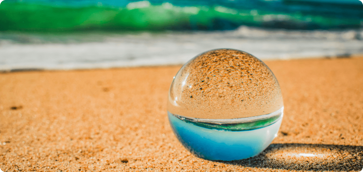 A transparent crystal ball on the san at a beach