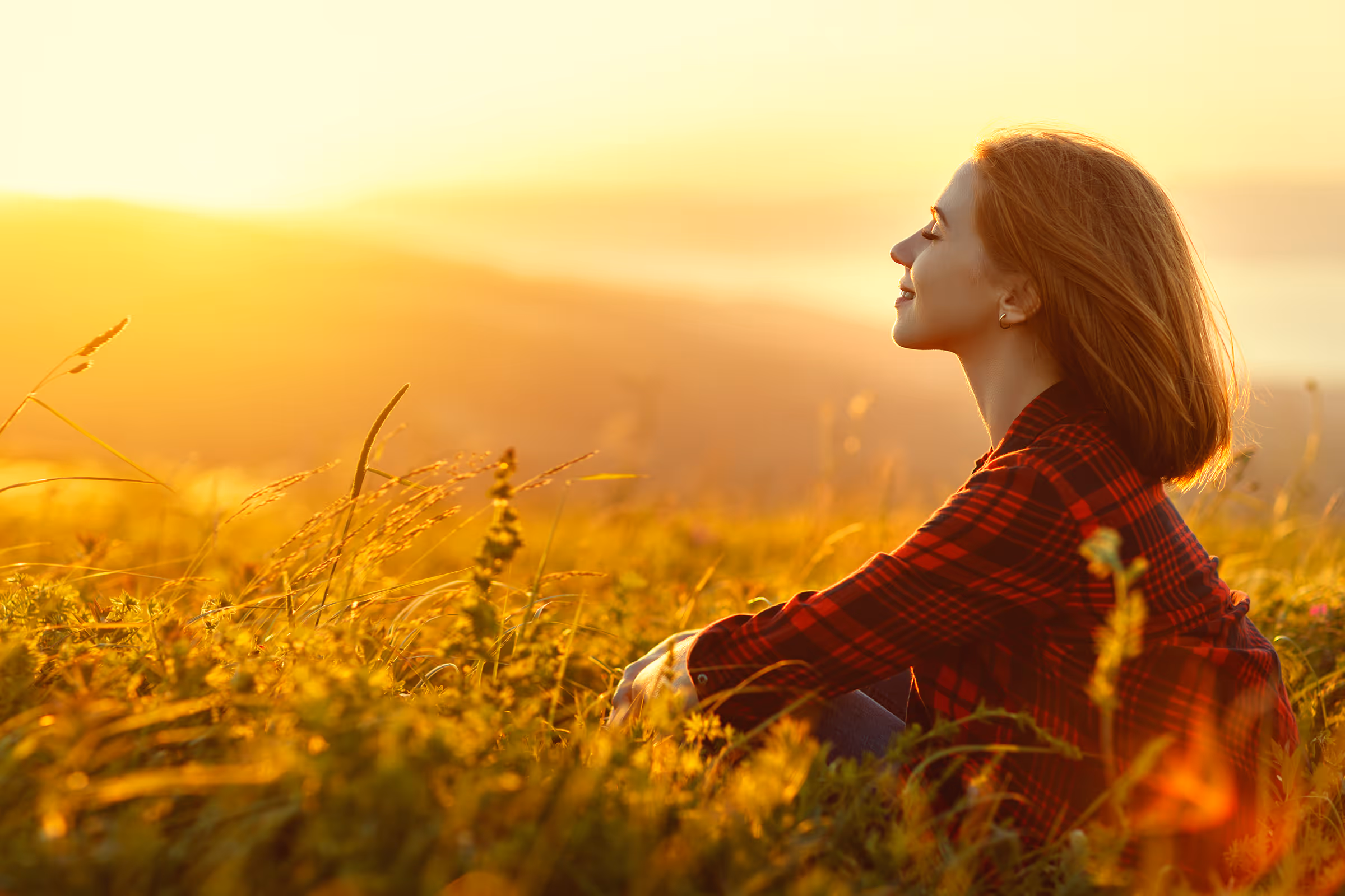 Happy peaceful woman sitting in a field of sunshine Avitia test finder