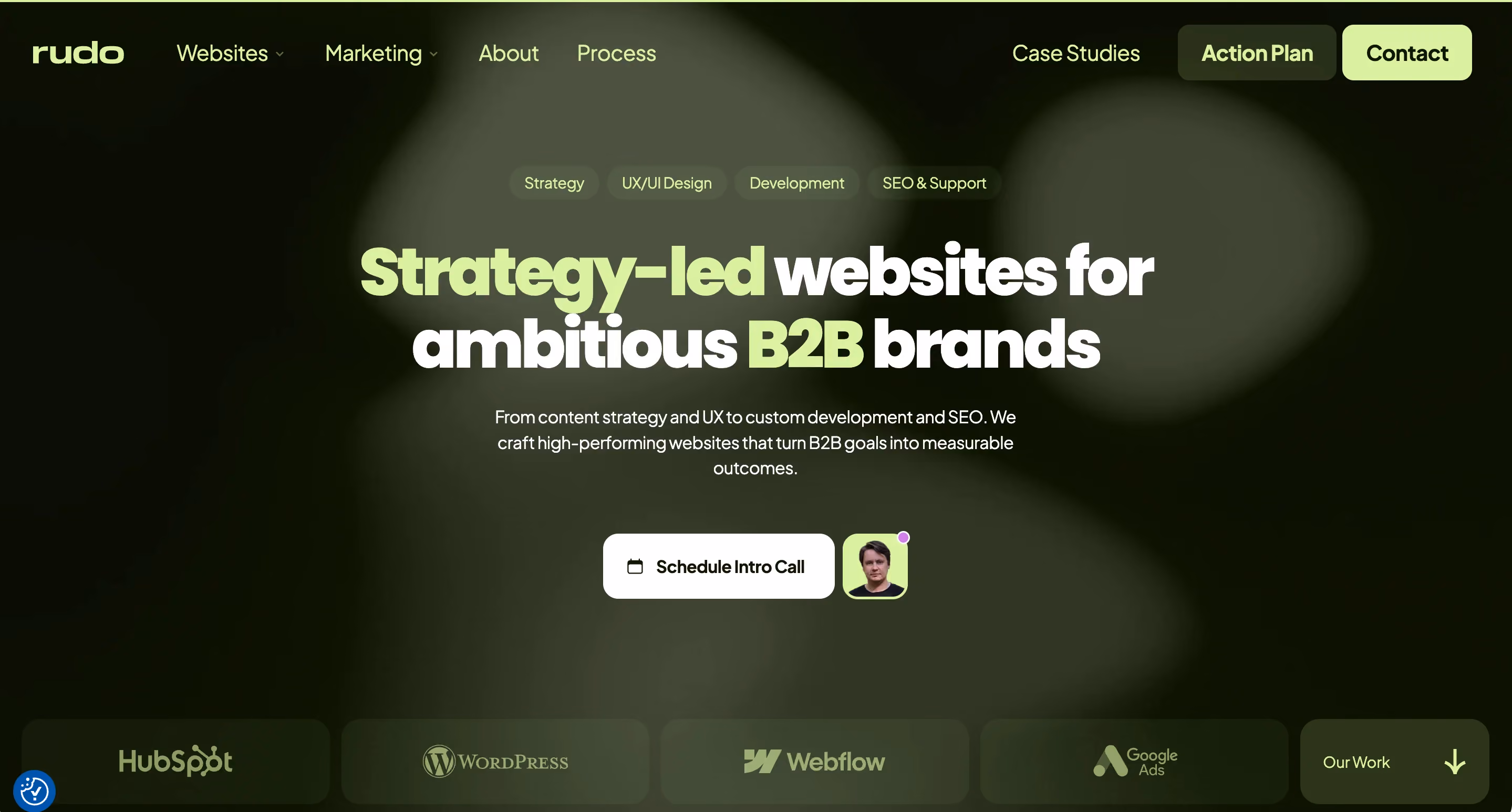 Rudo agency homepage with green-toned design showing the headline "Strategy-led websites for ambitious B2B brands" and platform logos for HubSpot, WordPress, Webflow, and Google Ads