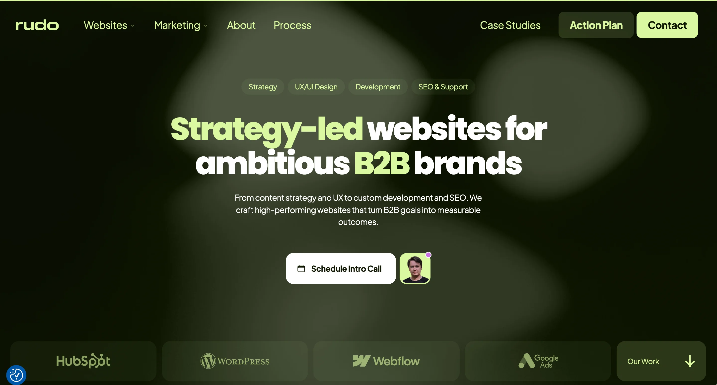 Rudo agency homepage with green-toned design showing the headline "Strategy-led websites for ambitious B2B brands" and platform logos for HubSpot, WordPress, Webflow, and Google Ads